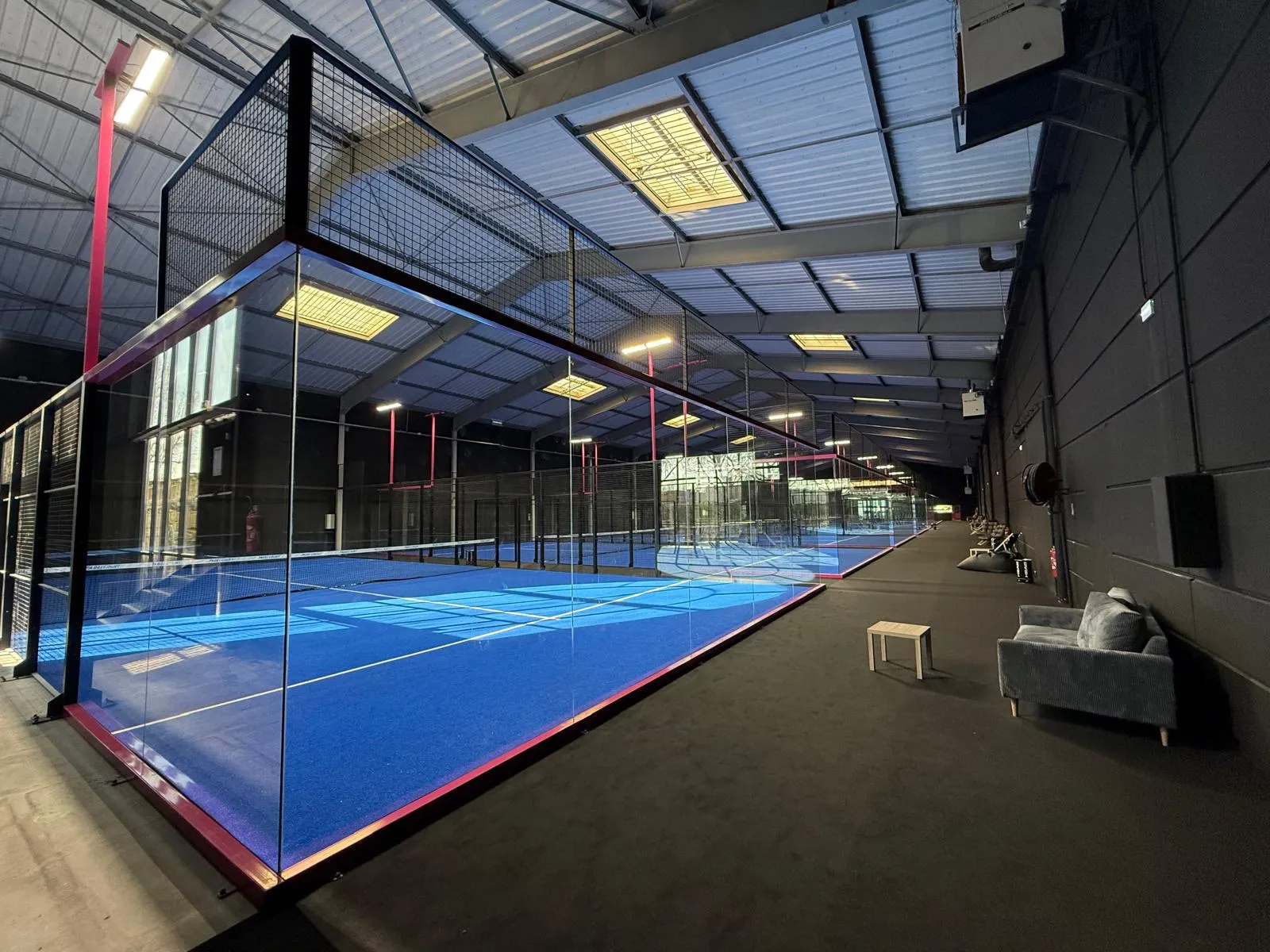 Pista de pádel indoor instalada con superficie azul y estructura completa