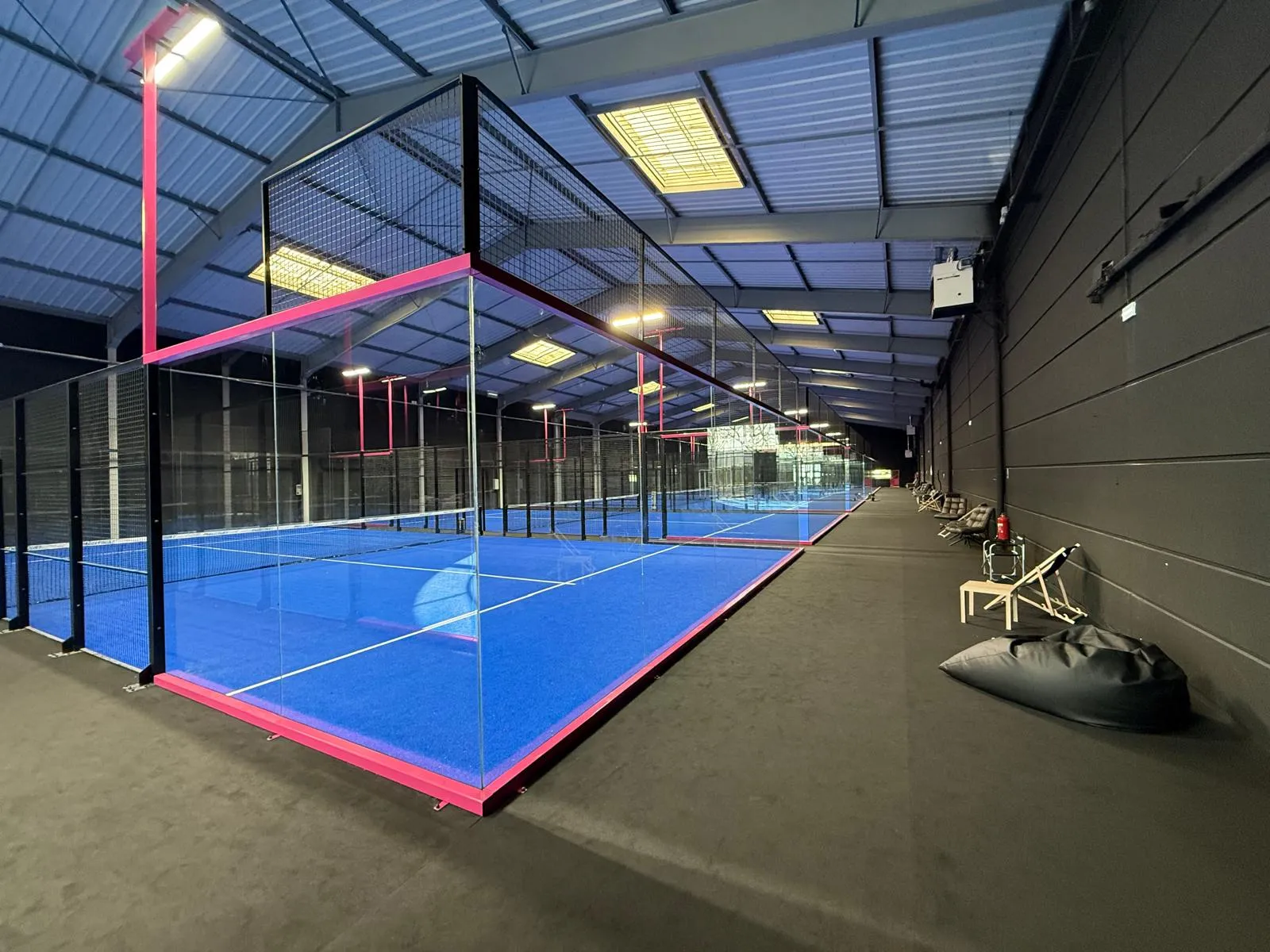 Exterior nocturno de instalación de pádel con iluminación profesional